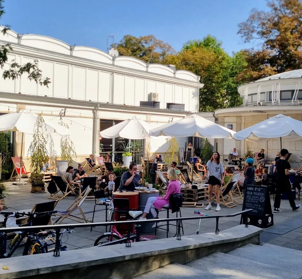 Modernistyczny budynek Kina Iluzjon i ogródek Stolica Café pełen gości